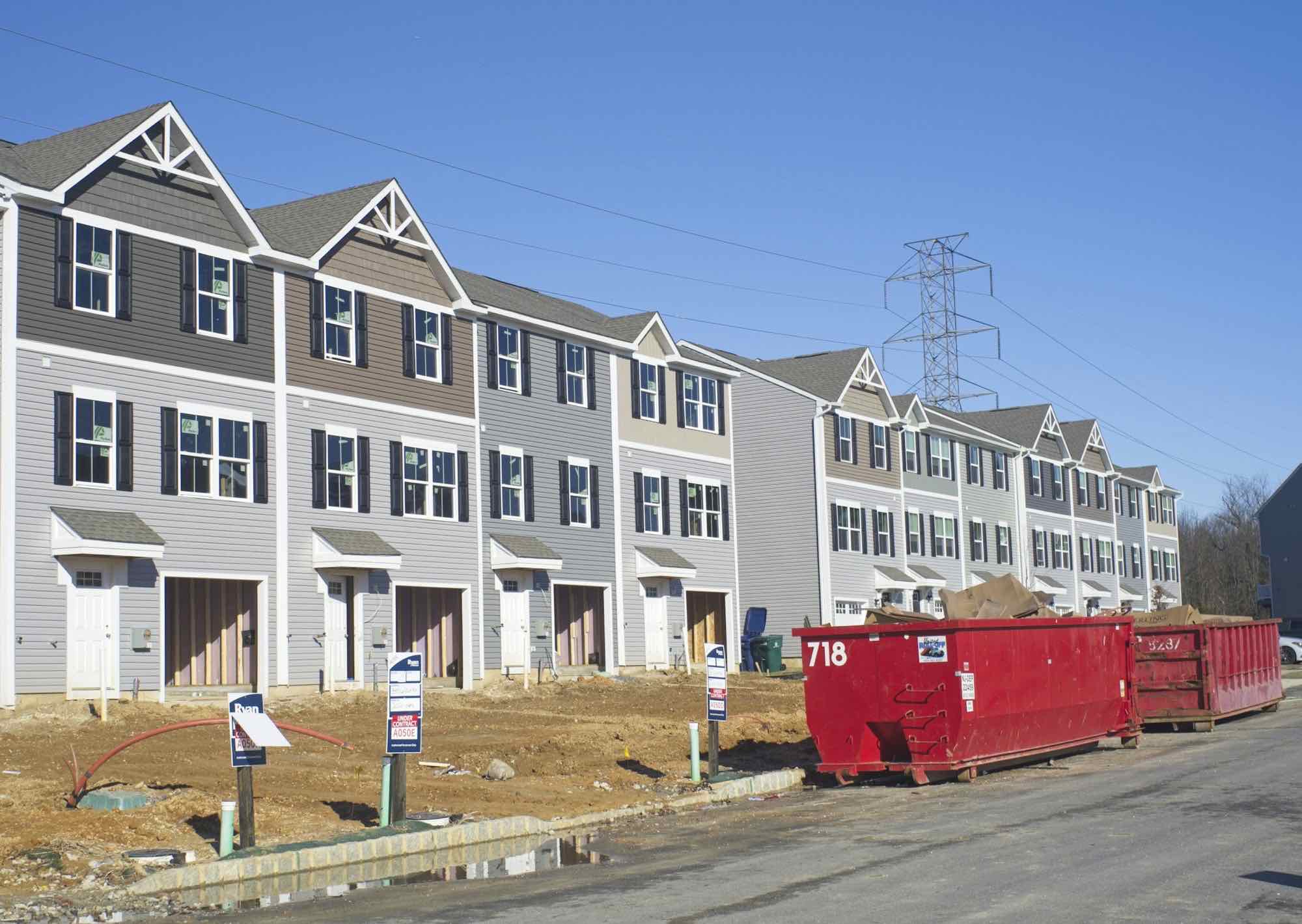 A row of townhomes under construction on a new street