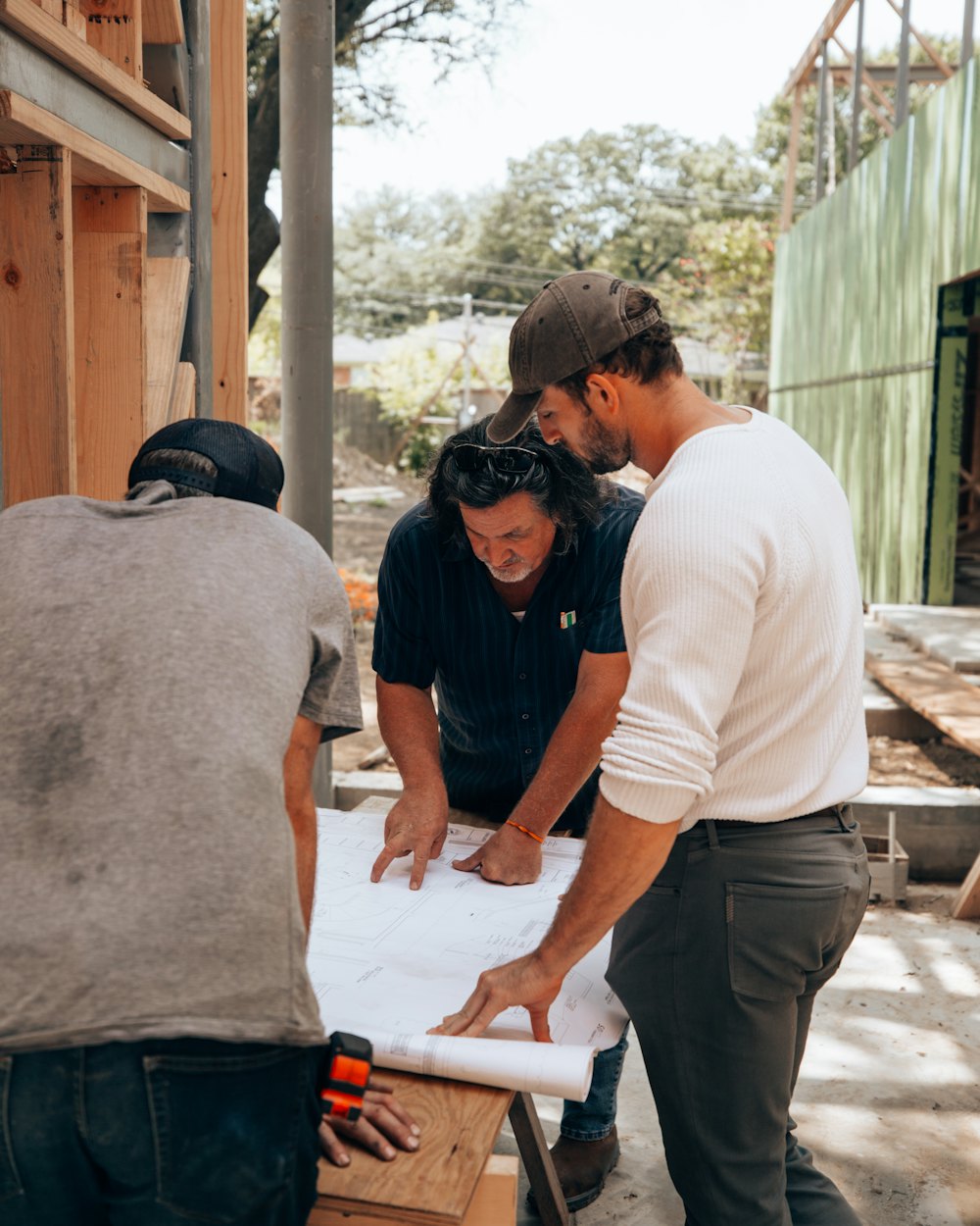 Three builders going over plans on a job site