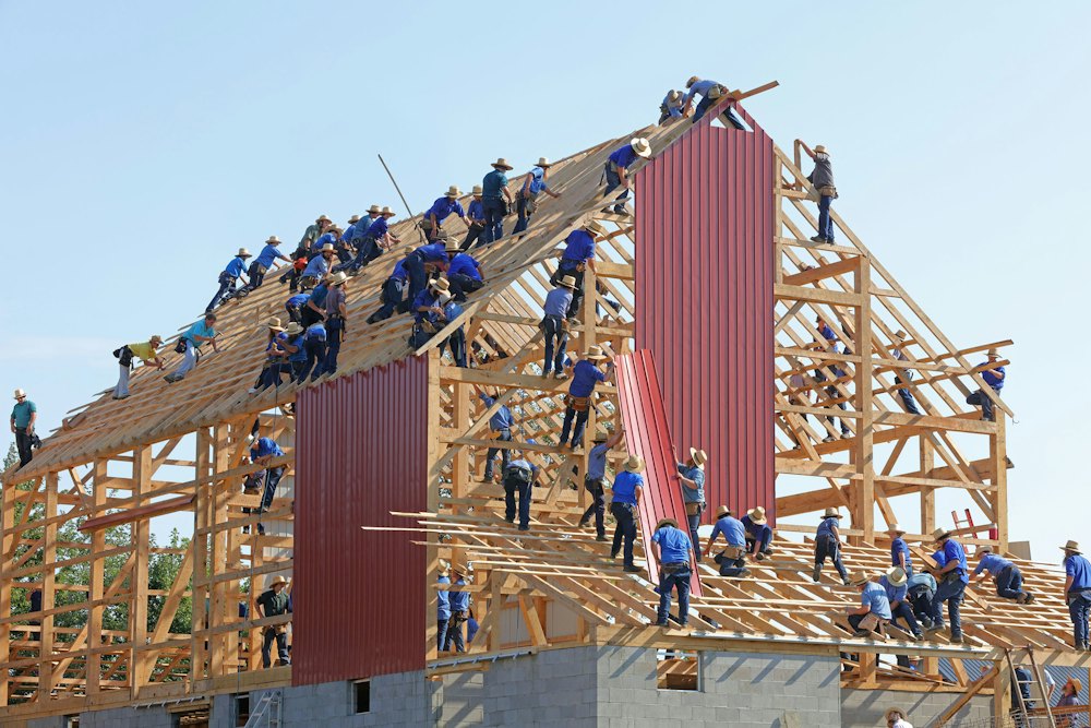 A crew raising the roof framing on a timber house