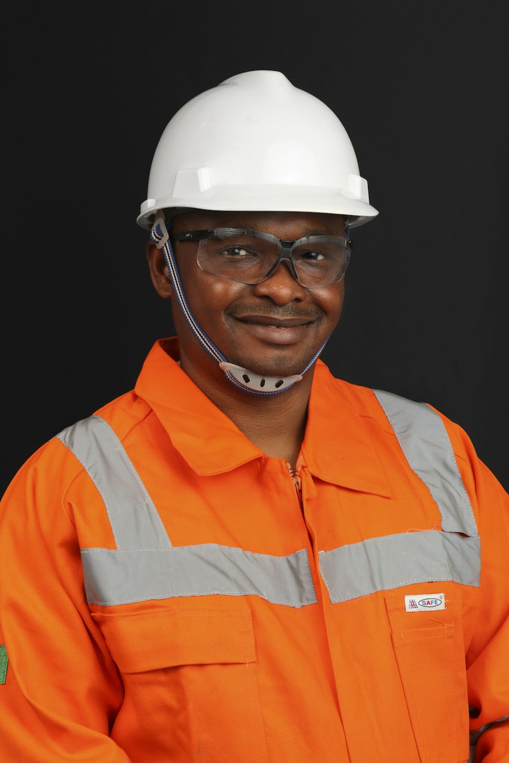 A smiling construction worker in a hard hat and hi-vis jacket