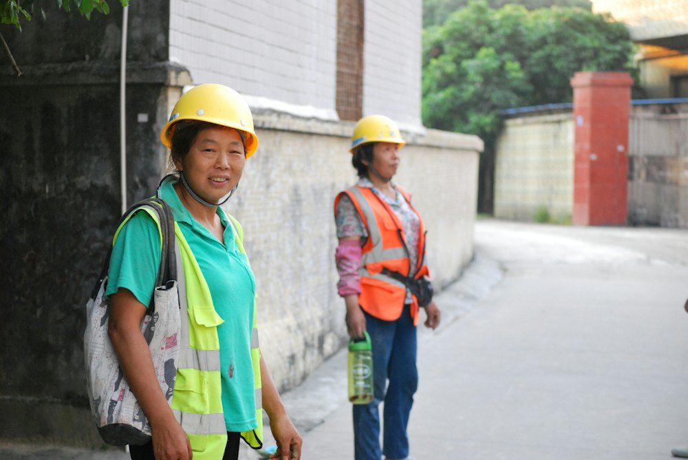 Two women in hard hats and safety vests on a job site