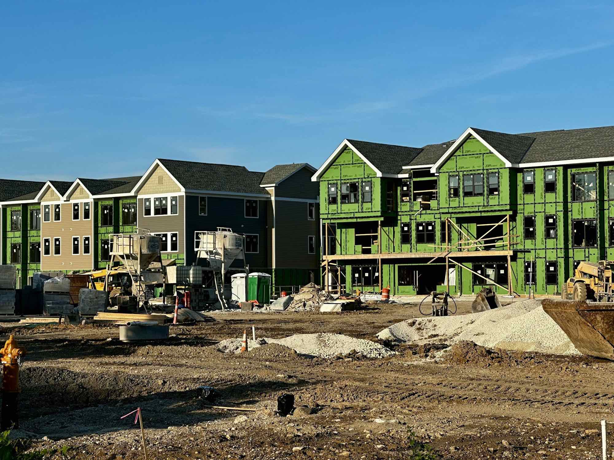 A street of new homes under construction, wrapped in house wrap