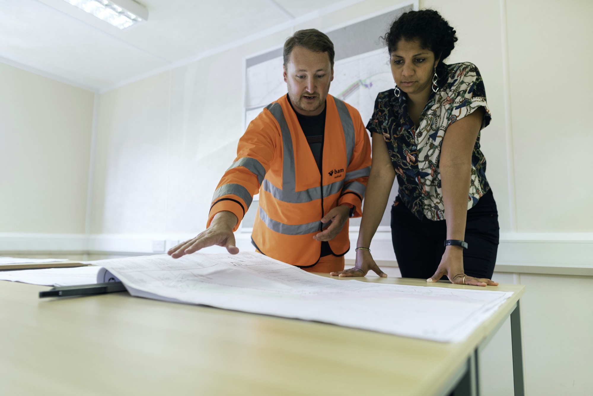 A site team in hi-vis reviewing plans together