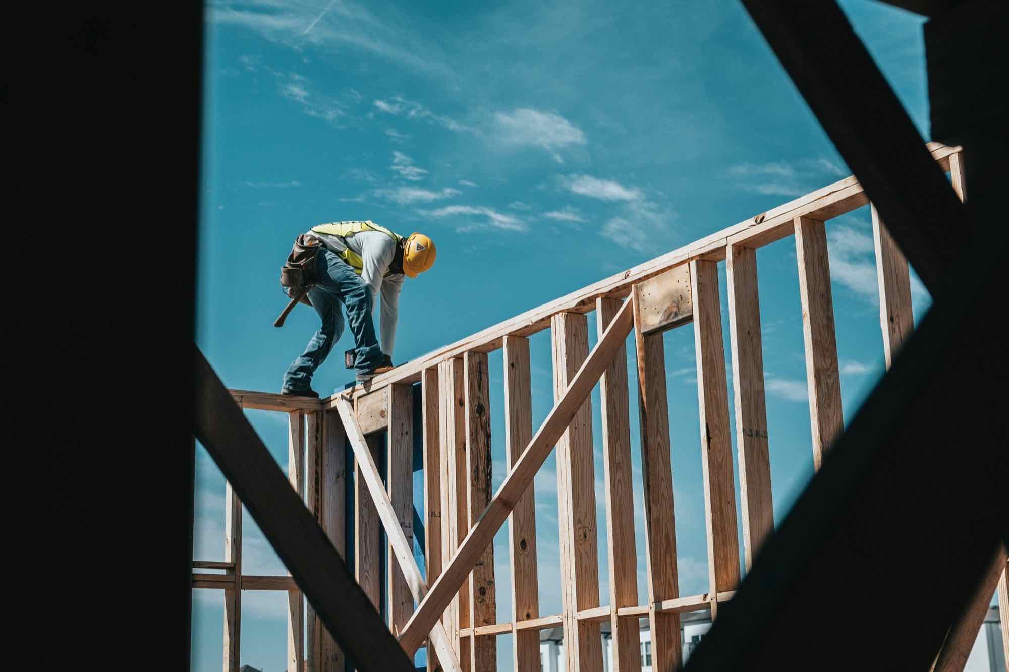 A framer working on the top plate of a timber-framed wall