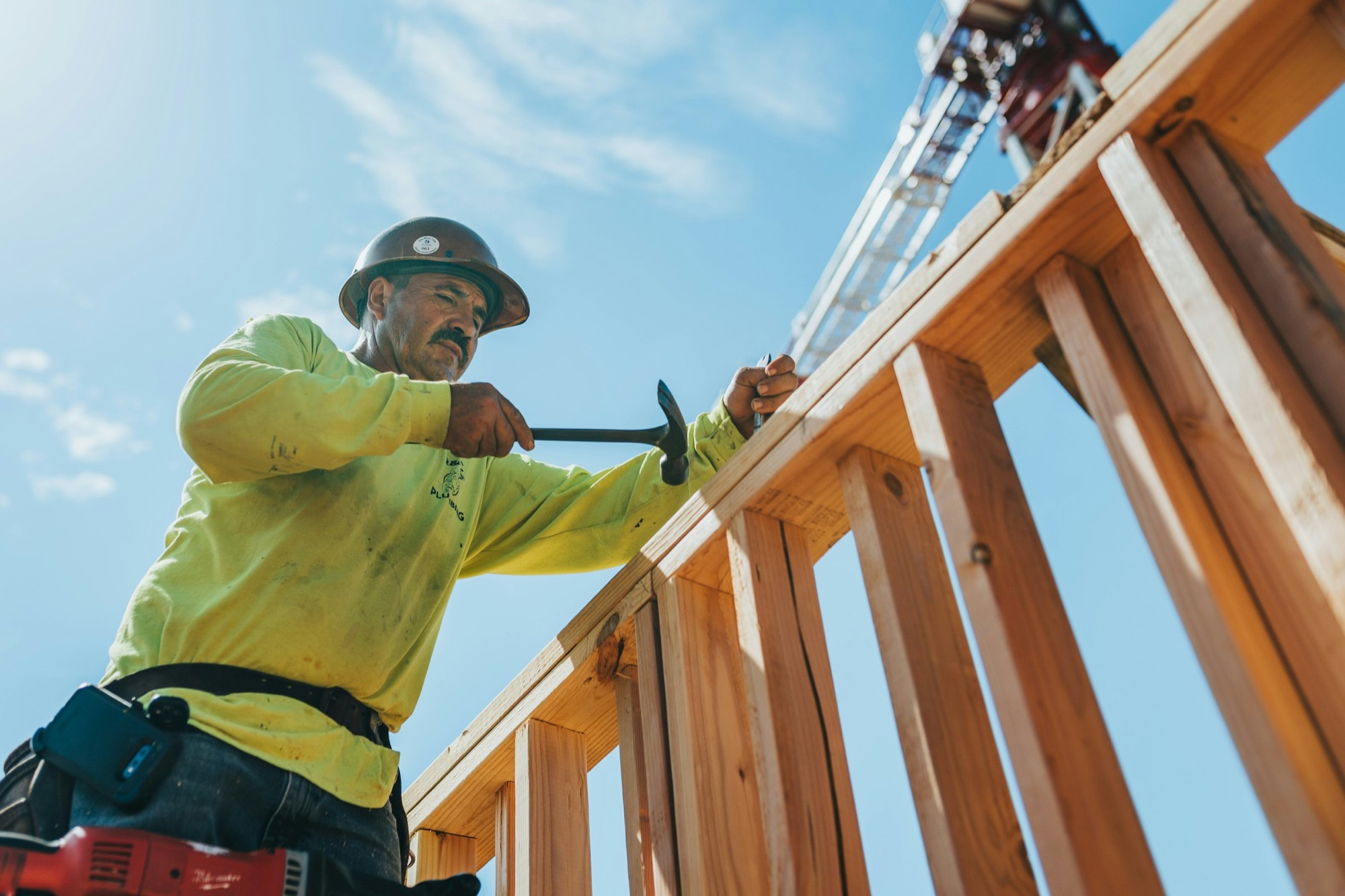 A roofer nailing off the framing on a new house